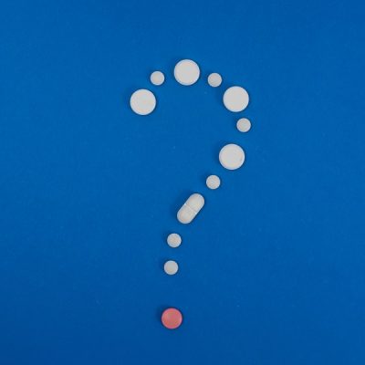 Question,Mark,Made,From,Capsules,Over,Blue,Background